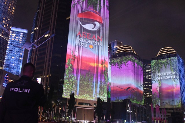 Petugas kepolisian berjaga dengan latar belakang pertunjukan video mapping saat Gala Dinner KTT ke-43 ASEAN 2023 di Senayan, Jakarta, Rabu (6/9/2023). Foto: Media Center KTT ASEAN 2023/Dhoni Setiawan/Antara Foto