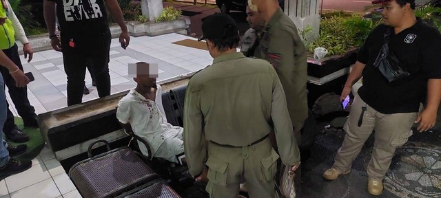 Petugas mengamankan WN AS Pamer Kelamin di Bandara Ngurah Rai, Bali. Foto: Dok. Polres Bandara Ngurah Rai