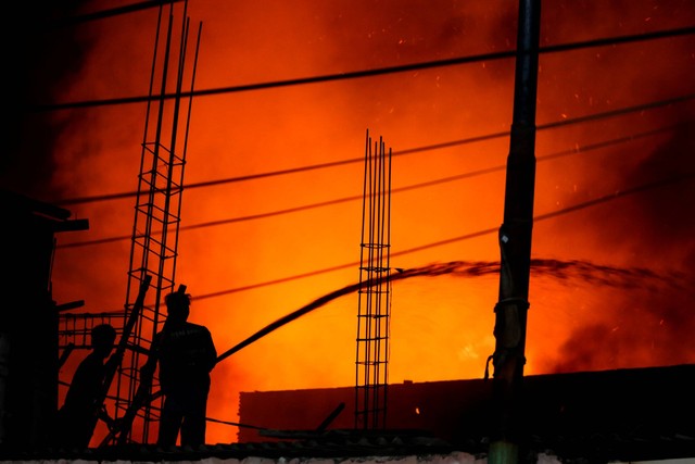 Sejumlah warga membantu memadamkan api yang membakar rumah warga di Jalan Krendang Utara, Tambora, Jakarta, Kamis (7/9/2023). Foto: Asprilla Dwi Adha/ANTARA FOTO