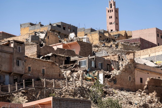 Menara masjid berdiri di belakang rumah-rumah yang hancur akibat gempa di Moulay Brahim, provinsi Al-Haouz, Maroko, Sabtu (9/9/2023).  Foto: FADEL SENNA / AFP