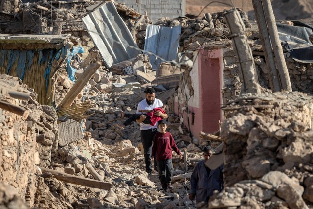 Warga berjalan melewati reruntuhan bangunan yang hancur akibat gempa di Moulay Brahim, provinsi Al-Haouz, Maroko, Sabtu (9/9/2023). Foto: FADEL SENNA / AFP