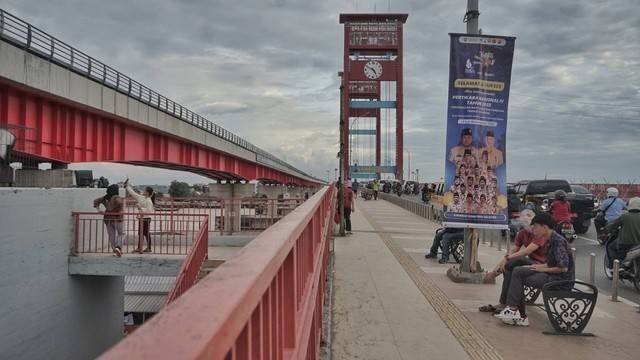 Sejumlah warga yang tengah bersantai sore di atas jembatan ampera yang tengah direnovasi melalui pembangunan lift untuk bagian dalam, Foto: abp/Urban Id