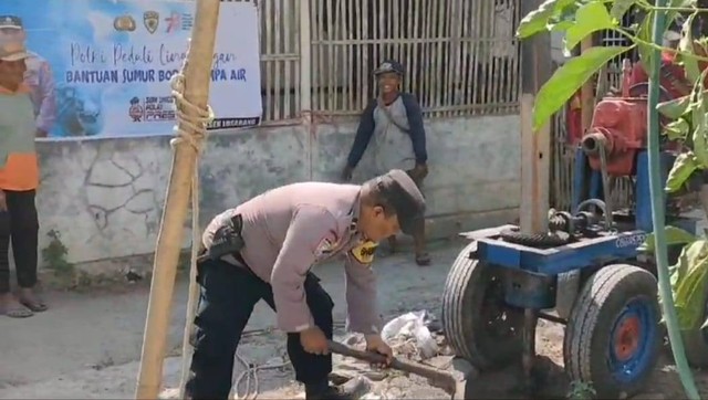 Anggota Polsek Losarang melakukan penggalian tanah menggunakan cangkul dalam proses pembuatan sumur di Desa Jangga, Indramayu. Foto : Tomi Indra Priyanto/Ciremaitoday