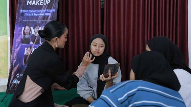 Salah seorang instruktur sedang memberikan contoh make up seorang anak panti asuhan. Foto: istimewa.