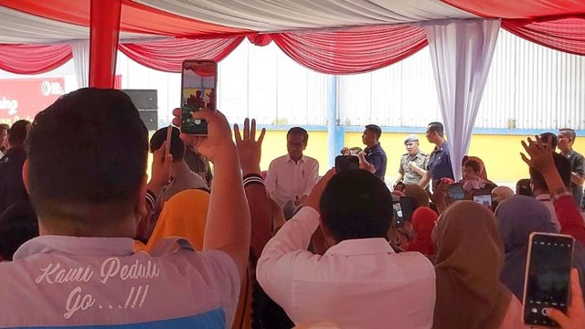 Presiden Jokowi memberikan bantuan sosial kepada keluarga penerima manfaat di Gudang Bulog Kelapa Gading, Jakarta, Senin (11/9/2023). Foto: Nadia Riso/kumparan