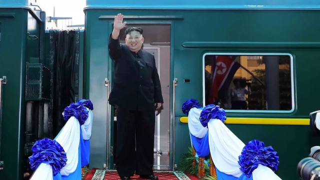 Kim Jong Un melambaikan tangan sebelum naik kereta untuk perjalanan.