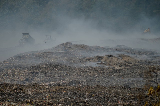 Alat berat menimbun sampah dengan tanah di lokasi terbakarnya TPA Sarimukti di Kabupaten Bandung Barat, Jawa Barat, Selasa (12/9/2023).  Foto: Raisan Al Farisi/ANTARA FOTO