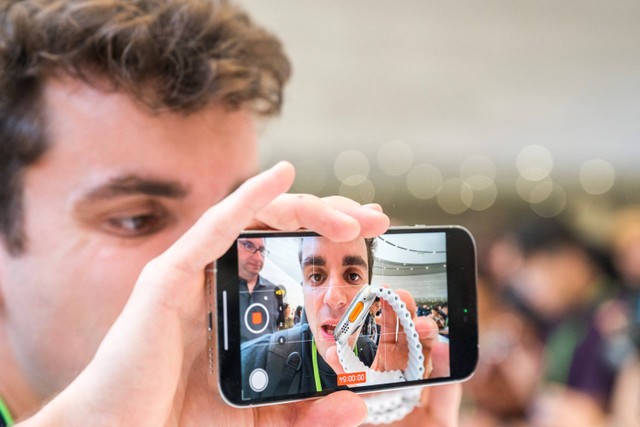 Pengunjung mencoba Apple iPhone 15 baru, dengan pengisi daya USB-C pesanan UE, ditampilkan di antara produk baru lainnya saat acara peluncuran di Apple Park di Cupertino, California, Selasa (12/9/2023). Foto: Nic Coury / AFP