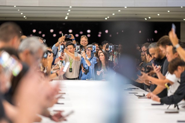 Pengunjung mencoba Apple iPhone 15 baru, dengan pengisi daya USB-C pesanan UE, ditampilkan di antara produk baru lainnya saat acara peluncuran di Apple Park di Cupertino, California, Selasa (12/9/2023). Foto: Nic Coury / AFP