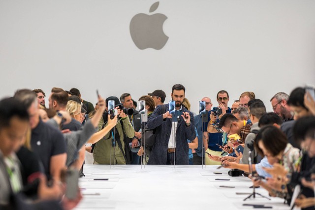 Pengunjung mencoba Apple iPhone 15 baru, dengan pengisi daya USB-C pesanan UE, ditampilkan di antara produk baru lainnya saat acara peluncuran di Apple Park di Cupertino, California, Selasa (12/9/2023). Foto: Nic Coury / AFP