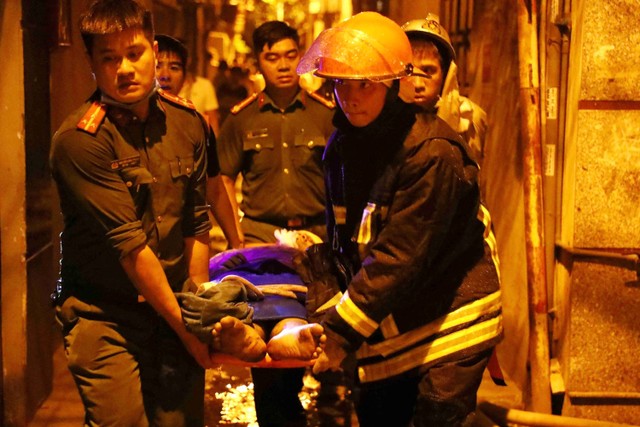 Evakuasi korban kebakaran di sebuah blok apartemen di Hanoi, Vietnam pada Rabu (13/9/2023). Foto: Le Phu/AFP