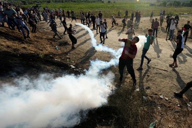 Pengunjuk rasa Palestina bentrok dengan pasukan keamanan Israel di sepanjang perbatasan dengan Israel saat demonstrasi menandai penarikan Israel dari Gaza pada tahun 2005, sebelah timur Kota Gaza, Rabu (13/9/2023). Foto: Adel Hana/AP Photo