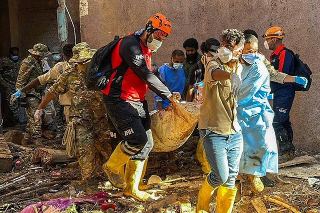 Petugas mengevakuasi korban banjir di Libya. Foto: Yousef Murad/AP