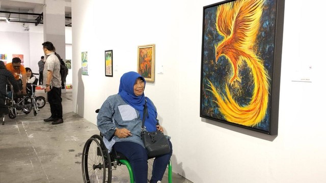 Salah seorang penyandang disabilitas saat melihat salah satu karya lukis di pameran TBY. Foto: