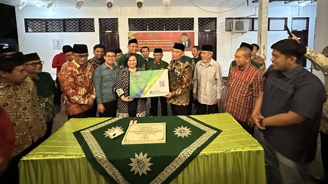 Menko PMK Muhadjir Effendy menyerahkan kartu BPJS Ketenagakerjaan saat Peresmian Perguruan Tinggi Muhammadiyah dan Aisyiah (PTMA) bertempat di Institut Teknologi dan Bisnis Muhammadiyah Polewali Mandar (ITBM Polman), Kamis (14/9). Foto: Dok. BPJS Ketenagake