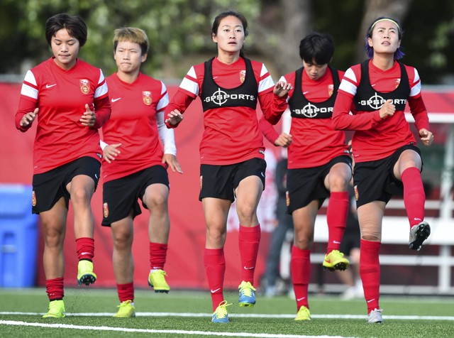 Anggota tim nasional Tiongkok melakukan pemanasan selama sesi latihan di Ottawa pada 23 Juni 2015 tiga hari sebelum pertandingan perempat final Piala Dunia Wanita FIFA 2015 melawan AS. Foto: NICHOLAS KAMM / AFP