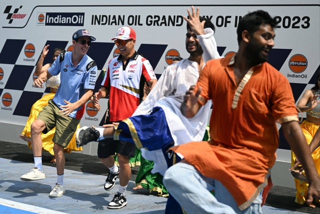 Pembalap Prima Pramac Racing asal Spanyol Jorge Martin (tengah) dan pebalap Gresini Racing MotoGP Spanyol Alex Marquez (kiri) berdansa menjelang Grand Prix MotoGP India di Sirkuit Internasional Buddh di Greater Noida, India. Foto: Money SHARMA / AFP