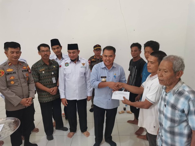 Bupati Aron menyerahkan bantuan kepada korban jembatan ambruk di Mentukak. Foto: Dok. Diskominfo Kabupaten Sekadau