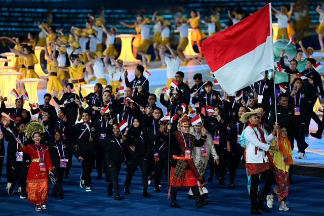 Anggota delegasi Indonesia mengikuti parade atlet pada upacara pembukaan Asian Games 2022 di Stadion Pusat Olahraga Olimpiade Hangzhou di Hangzhou di provinsi Zhejiang timur China, Sabtu (23/9/2023). Foto: Ishara S.KODIKARA/AFP