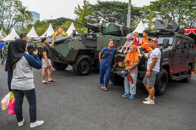 Sejumlah warga berfoto didepan kendaraan milik TNI saat pameran alutsista di kawasan Monas, Jakarta, Minggu (24/9/2023). Foto: Galih Pradipta/Antara Foto