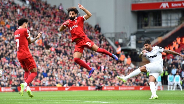Pemain Liverpool Mohamed Salah menghadang tendangan pemain West Ham United Emerson Palmieri pada pertandingan lanjutan Liga Inggris di Anfield, Liverpool, Inggris, Minggu (24/9/2023). Foto: Peter Powell/REUTERS