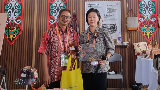 Manager Digitalisasi & Monetasi UMK Telkom, Achmad Retno Syafarie (kiri) bersama pengunjung yang membeli produk batik bag dari Soko Craft Pekalongan dalam gelaran China-ASEAN Expo. Foto: dok. Telkom