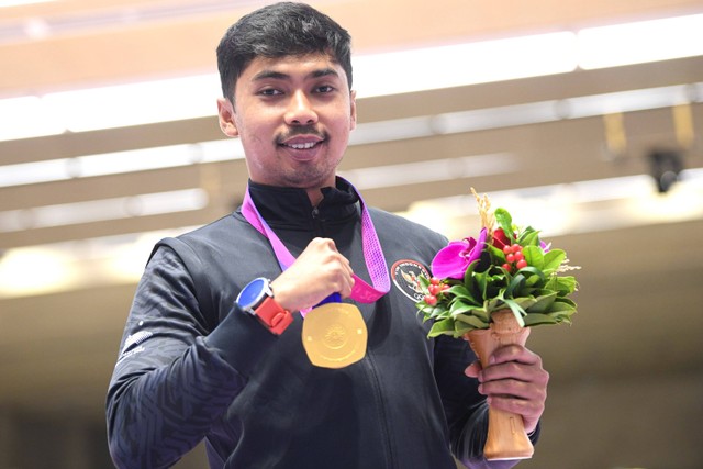 Petembak tunggal putra Indonesia Muhammad Sejahtera Dwi Putra berpose dengan medali emasnya usai upacara penghargaan pemenang final 10 meter running target Asian Games 2022 di Fuyang Yinhu Sports Centre, Hangzhou, China, Senin (25/9/2023). Foto: M Risyal Hidayat/ANTARA FOTO