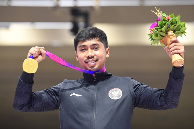 Petembak tunggal putra Indonesia Muhammad Sejahtera Dwi Putra berpose dengan medali emasnya usai upacara penghargaan pemenang final 10 meter running target Asian Games 2022 di Fuyang Yinhu Sports Centre, Hangzhou, China, Senin (25/9/2023). Foto: M Risyal Hidayat/ANTARA FOTO