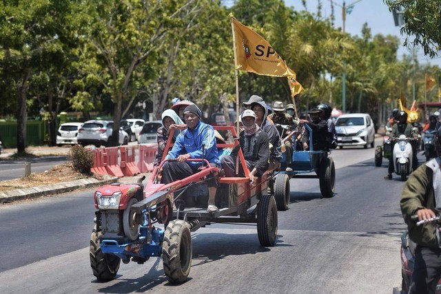 Massa menaiki traktor menuju lokasi demo. Dok: Panji Asmara/kumparan.