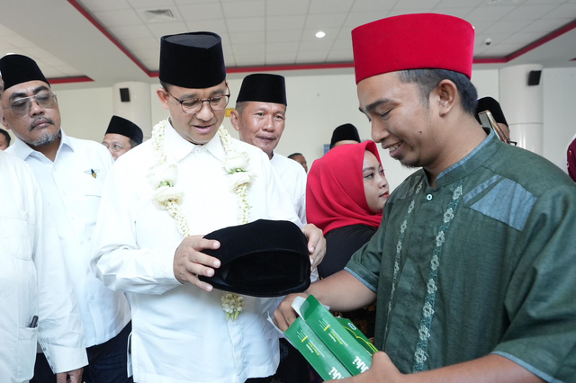 Bacapres Anies Baswedan saat dihadiahi songkok dari santri sekaligus pengusaha UMKM dari Ponpes Darul Aitam Karang Bistah Sampang, Habibullah Salim, Jumat (29/9). Foto: Dok. Istimewa