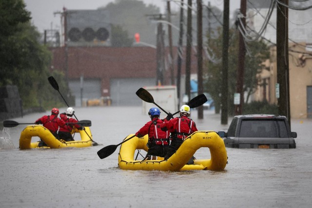 Personel penyelamat Unit Operasi Khusus dengan Layanan Darurat Westchester County mendayung dengan rakit saat mereka mencari korban banjir, di Mamaroneck pinggiran Kota New York, New York, AS, Jumat (29/9/2023). Foto: Mike Segar/REUTERS