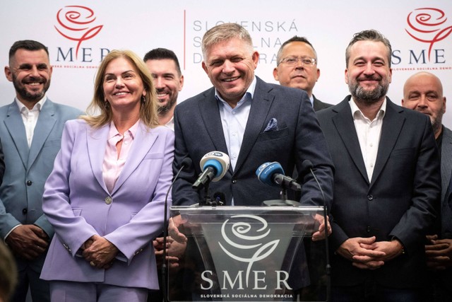 Ketua partai Smer-Social Democracy Robert Fico (tengah) tersenyum saat berpidato di konferensi pers di markas besar partainya setelah pemilihan parlemen awal di Bratislava, Slovakia pada 1 Oktober 2023. Foto: Vladimir Simicek/AFP