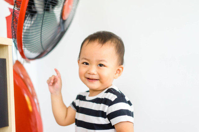 Ilustrasi anak berada di depan kipas angin. Foto: MIA Studio/Shutterstock