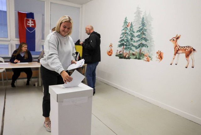 Seseorang memberikan suara di tempat pemungutan suara selama pemilihan parlemen awal di Bratislava, Slovakia, Sabtu (30/9/2023). Foto: Eva Korinkova/REUTERS