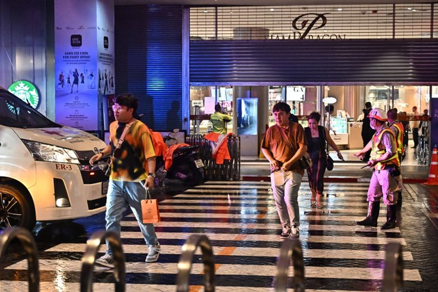 Sejumlah pengunjung meninggalkan pusat perbelanjaan Siam Paragon di Bangkok pada Selasa (3/10/2023). Foto: Lillian Suwanrumpha/AFP