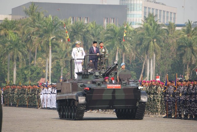 Presiden Joko Widodo (tengah) menaiki kendaraan tempur saat memeriksa pasukan saat Upacara Perayaan HUT TNI ke-78 di Kawasan Monas, Jakarta, Kamis (5/10/2023). Foto: Iqbal Firdaus/kumparan