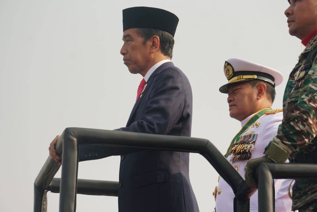 Presiden Joko Widodo (tengah) menaiki kendaraan tempur saat memeriksa pasukan saat Upacara Perayaan HUT TNI ke-78 di Kawasan Monas, Jakarta, Kamis (5/10/2023). Foto: Iqbal Firdaus/kumparan