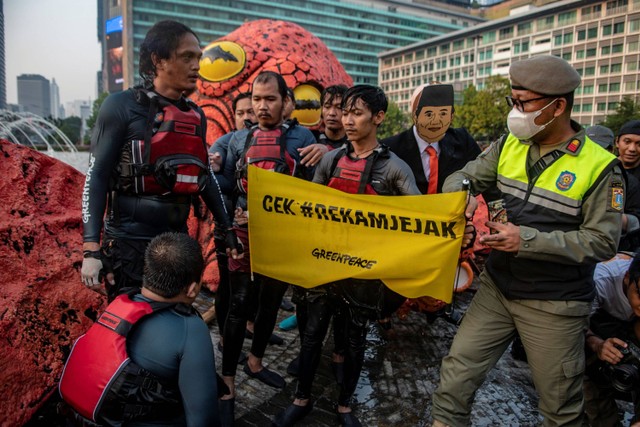 Petugas Satpol PP membubarkan aksi aktivis Greenpeace Indonesia saat menggelar kampanye tanpa oligarki di Bundaran Hotel Indonesia (HI), Jakarta, Jumat (6/10/2023). Foto: Muhammad Adimaja/ANTARA FOTO