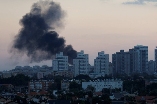 Asap mengepul setelah roket diluncurkan dari Jalur Gaza, di Ashkelon, Israel, Sabtu (7/10/2023). Foto: Amir Cohen/REUTERS