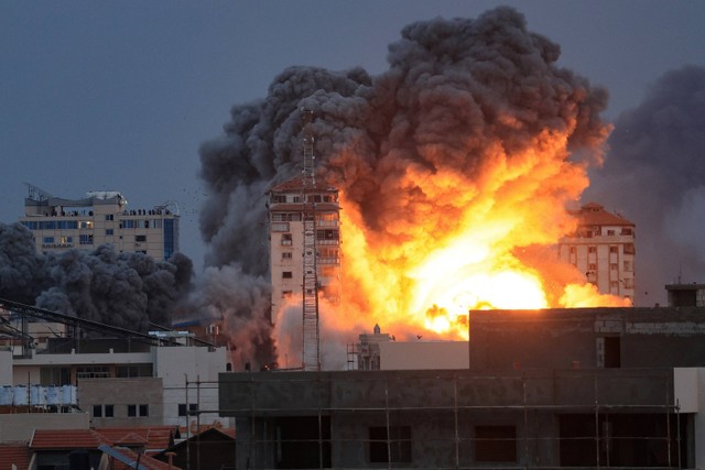 Api dan asap membubung di atas gedung-gedung selama serangan udara Israel di Kota Gaza, Sabtu (7/10/2023).  Foto: MAHMUD HAMS/AFP