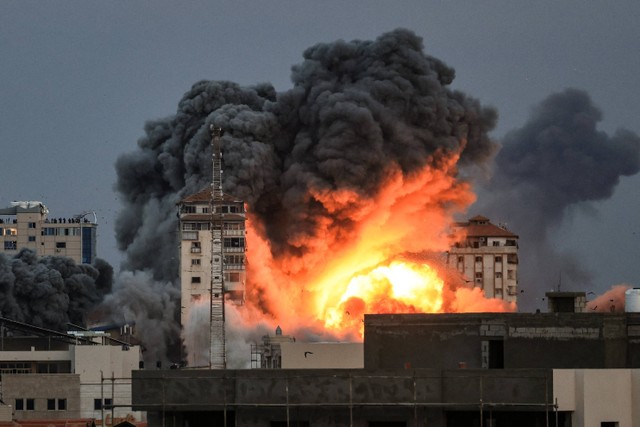 Api dan asap membubung di atas gedung-gedung selama serangan udara Israel di Kota Gaza, Sabtu (7/10/2023).  Foto: MAHMUD HAMS/AFP