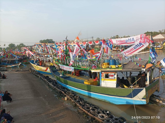 Perahu-perahu nelayan yang sudah dihiasi untuk ikut pawai melarung kepala kerbau di tengah laut. Sumber: Dokumen Pribadi.