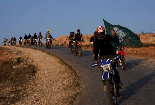 Pendukung Hizbullah konvoi sepeda motor di Kfar Kila, Lebanon, Minggu (8/10/2023). Foto: Hussein Malla/AP PHOTO