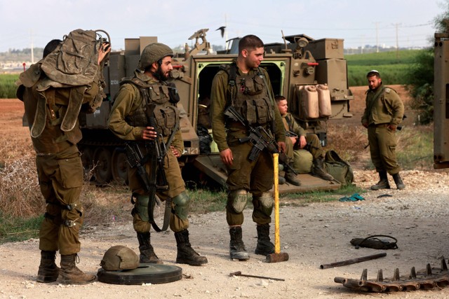 Pasukan Israel berkumpul di lokasi yang dirahasiakan di perbatasan dengan Jalur Gaza, Minggu (8/10/2023).  Foto: Menahem KAHANA / AFP