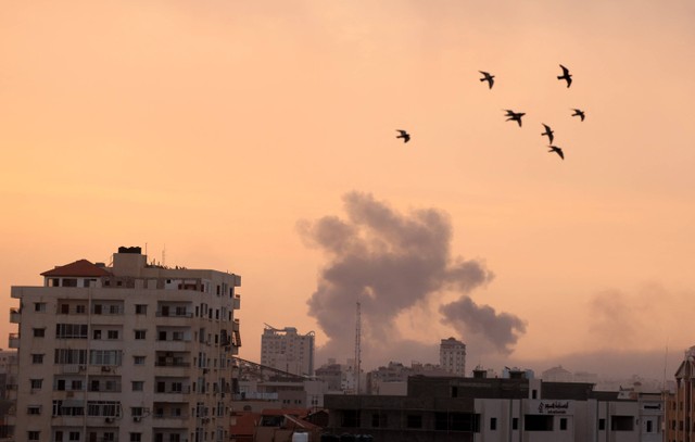 Asap mengepul di atas gedung-gedung selama serangan udara Israel, di Kota Gaza, Senin (9/10/2023).  Foto: MAHMUD HAMS / AFP