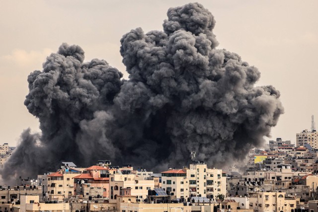 Asap mengepul di atas gedung-gedung selama serangan udara Israel, di Kota Gaza, Senin (9/10/2023).  Foto: MAHMUD HAMS / AFP