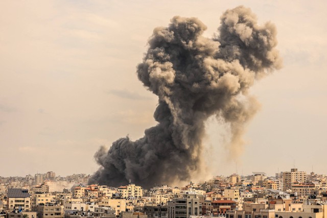 Asap mengepul di atas gedung-gedung selama serangan udara Israel, di Kota Gaza, Senin (9/10/2023).  Foto: MAHMUD HAMS / AFP