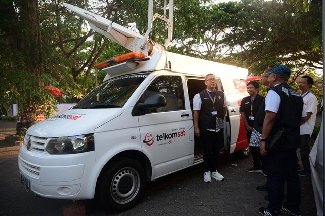 SVP Corporate Communication & Investor Relation Telkom, Ahmad Reza (paling kiri) memastikan kesiapan Satellite News Gathering milik Telkomsat dalam momen KTT AIS 2023 Forum, di Nusa Dua, Selasa (10/10). Foto: Telkom