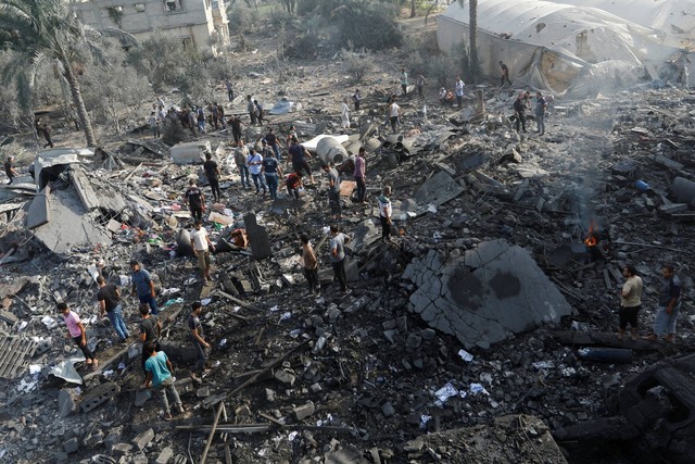 Warga Palestina berkumpul di puing-puing pasca serangan Israel, di Khan Younis di selatan Jalur Gaza, Rabu (11/10/2023). Foto: Ibraheem Abu Mustafa/REUTERS