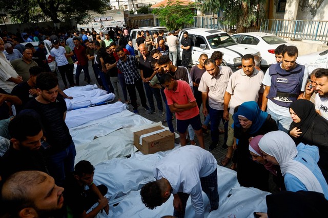 Keluarga dan kerabat berkumpul di samping jenazah warga Palestina yang tewas dalam serangan Israel, di sebuah rumah sakit di Kota Gaza, Rabu (11/10/2023). Foto: Mohammed Salem/REUTERS